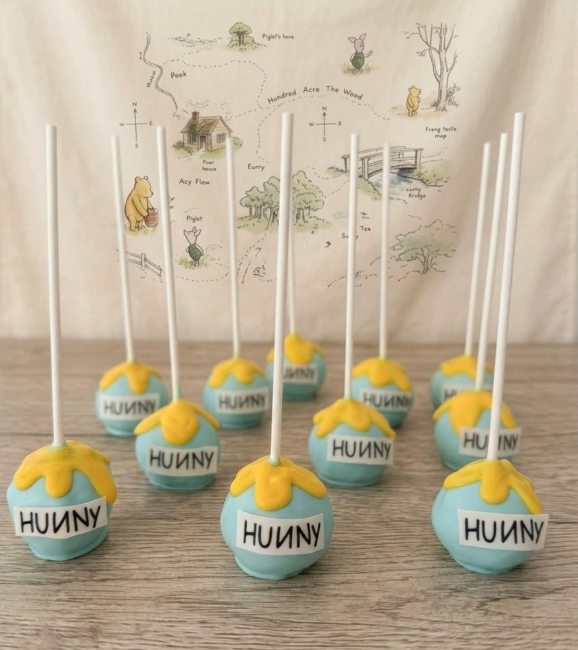 Handcrafted Winnie the Pooh cake pops and cake popsicles individually wrapped for baby showers and 1st birthdays. Order custom 24-piece dessert sets online today.