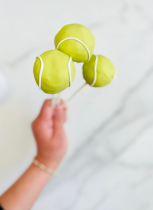 Tennis ball cake pops 12 count decorated with realistic tennis ball designs for sports parties and celebrations.
Handmade tennis ball cake pops with green and white details, perfect for tennis birthdays and team events.